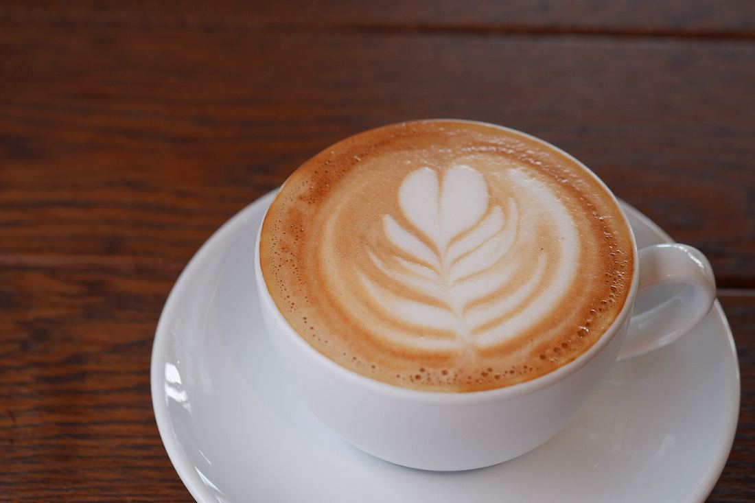 Un cappuccino con il disegno a foglia nella schiuma